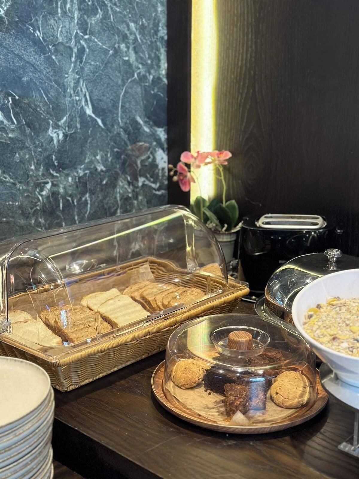 Un bufé de desayuno con pan, galletas y una estación de café.