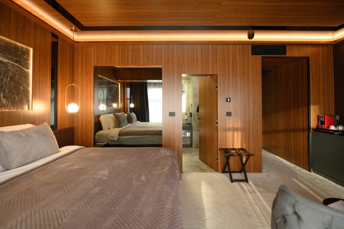 A modern hotel room with a large bed, a desk, and a seating area.