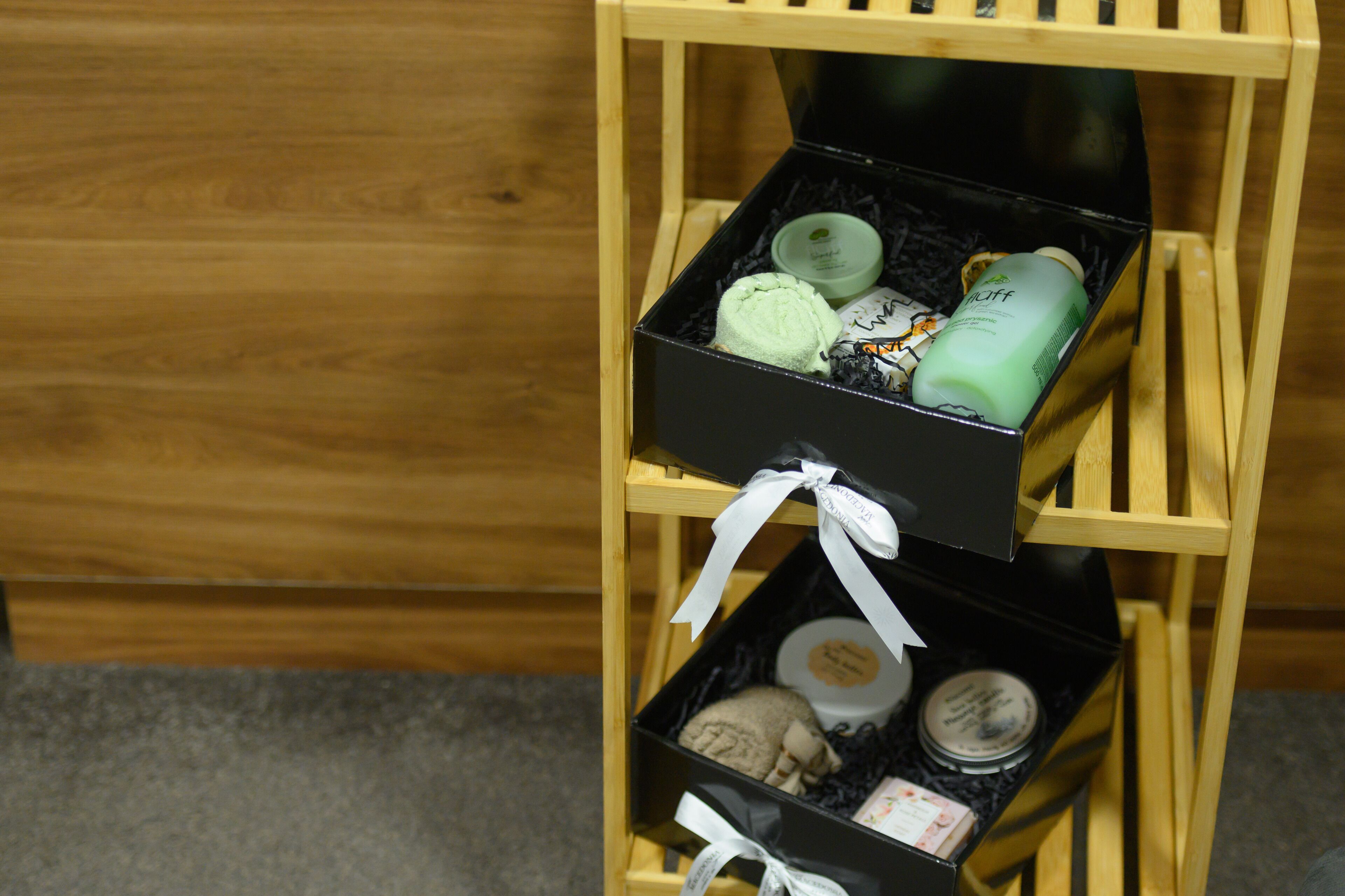 Un expositor de madera con dos cajas negras que contienen diversos artículos.