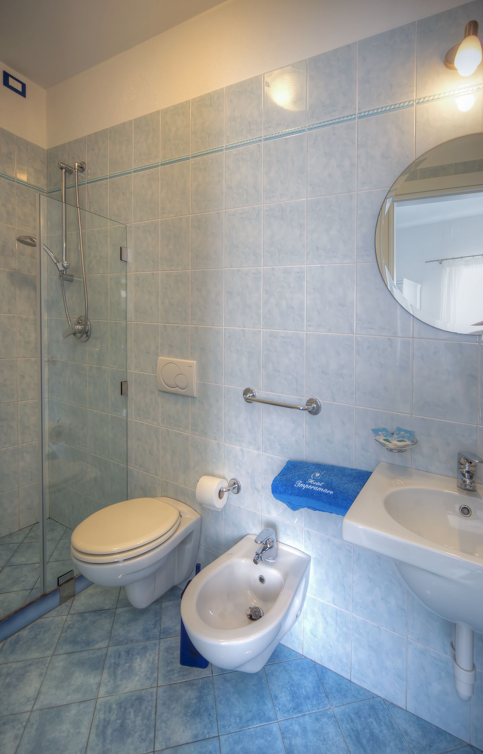A bathroom with a toilet, bidet, and shower.