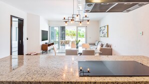 A modern kitchen with granite countertops, a built-in oven, and a stainless steel range hood. - Casa Lucerna Splash Pool Unit,Where the Caribbean feels like home (Playa del Carmen)