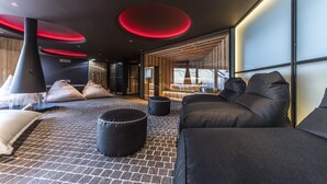 A modern interior with a black sofa, black ottoman, and a patterned rug. - Romantic escape in luxury Italian villa, (Veneto)