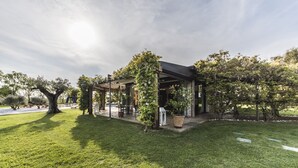 A covered outdoor seating area with a pool, surrounded by lush greenery and trees. - Romantic escape in luxury Italian villa, (Veneto)