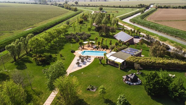 An aerial view of a property with a swimming pool, solar panels, and a well-maintained lawn. - Romantic escape in luxury Italian villa, (Veneto)