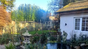 Un jardin agrémenté d’un bassin, de lanternes en pierre et de statues.