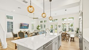A spacious kitchen with a large island, stainless steel appliances, and pendant lighting. - Inviting Beach Home w/ Cinnamon Shore South Style & Amenities (Port Aransas)
