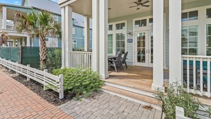 A coastal house with a covered porch, a dining area, and a pool. - Inviting Beach Home w/ Cinnamon Shore South Style & Amenities (Port Aransas)