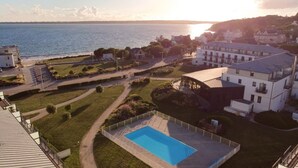 Ett bostadsområde med en swimmingpool, en väg och byggnader i bakgrunden.