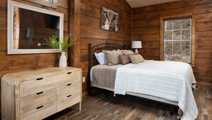 A wooden cabin bedroom with a bed, dresser, and a ceiling fan. - Walk2DowntownPF/GasFirepit/Waterfront (Pigeon Forge)