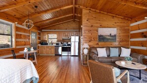A log cabin interior with a kitchen, dining area, and living room. - Big Mt. LeConte Views/Gatlinburg (Gatlinburg)