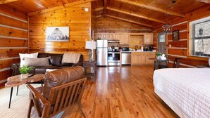 A log cabin interior with a living area, kitchenette, and a bed. - Amazing Mt. LeConte Views/Gatlinburg (Gatlinburg)