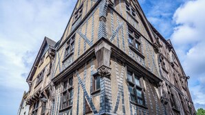 Il s’agit d’un bâtiment historique dont l’architecture remarquable se caractérise par un angle distinctif, une combinaison de pierres et de briques, ainsi que par de nombreuses fenêtres.