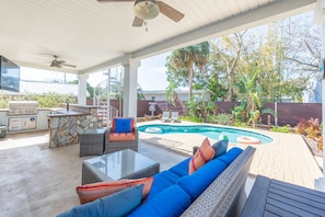 A covered outdoor patio with a pool, seating area, and barbecue setup. - 4BR Private Pool Oasis | Sleeps 12 • Pet Friendly (St. Augustine)