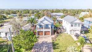 A two-story house with a covered porch, a garage, and a fenced yard. - 4BR Private Pool Oasis | Sleeps 12 • Pet Friendly (St. Augustine)