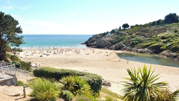 A beach with a clear view of the sea, a sandy shore, and a rocky hillside. - -LITTO- CONCARNEAU AVEC TERRASSE PROCHE COMMERCES (Concarneau)