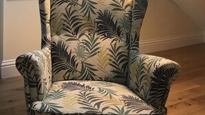 A room with a high ceiling, a skylight, a chair with a leaf pattern, a painting of an elephant, and a floor lamp. - Windows Over Stroud Penthouse Apartment With Views (Stroud)