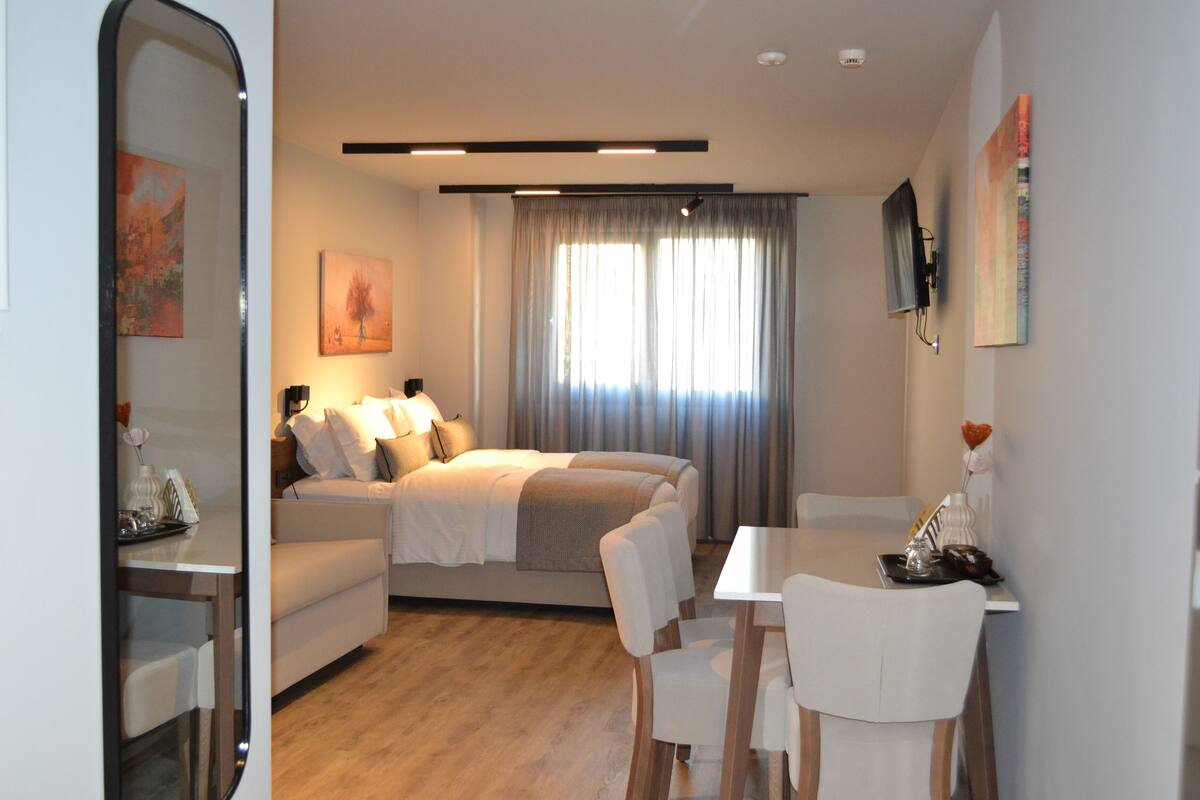 Une chambre moderne avec un lit, une table de chevet et un bureau avec des chaises.
