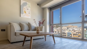 Una sala de estar moderna con un sofá, una mesa de centro de madera y un florero con flores.