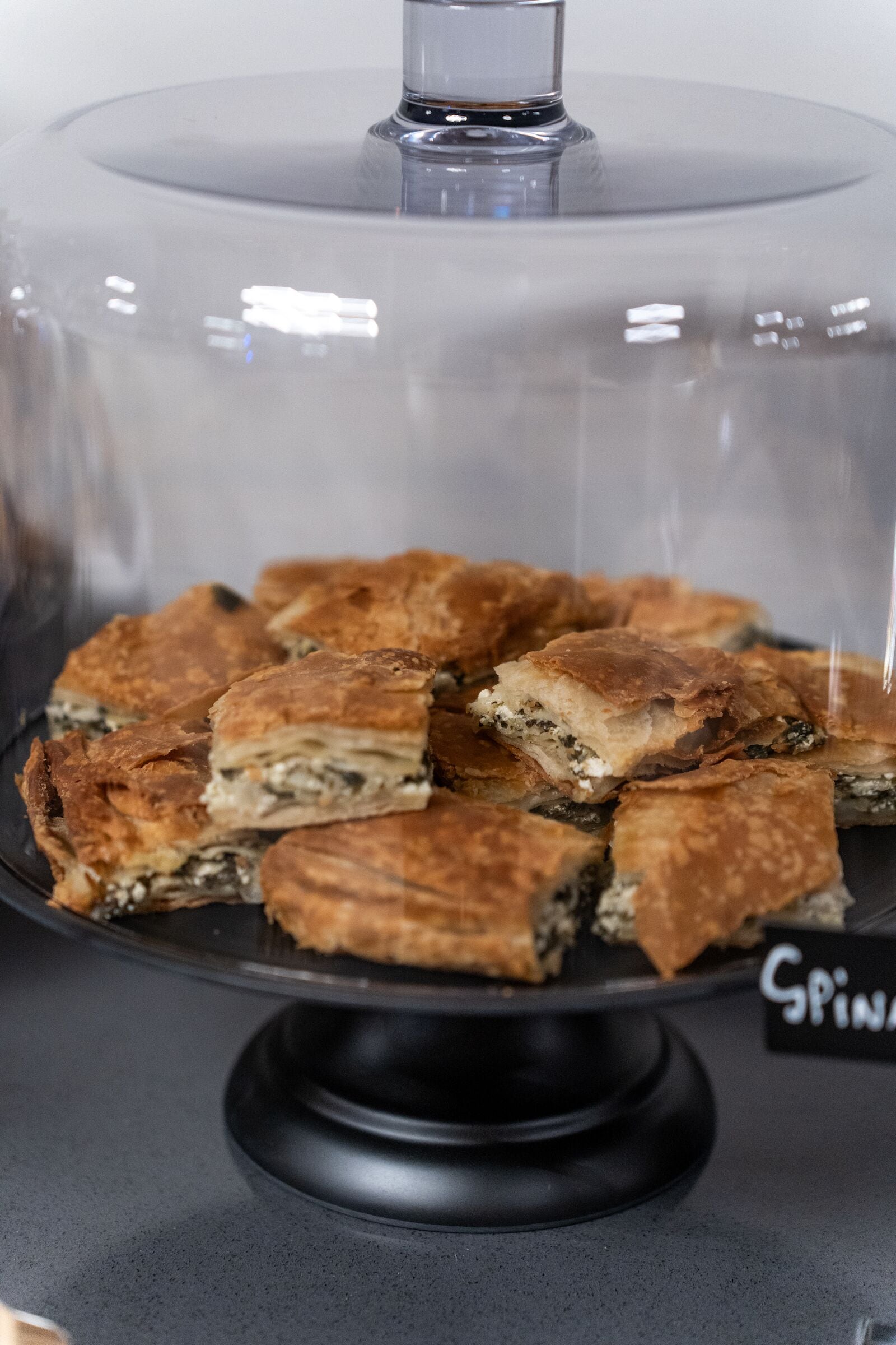 A display case with a glass cover, containing several pieces of food.