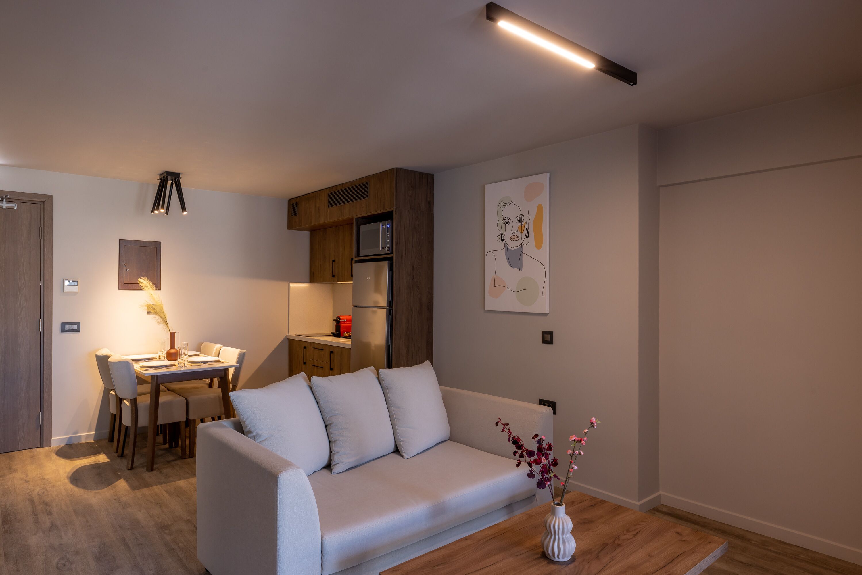 Una sala de estar moderna con sofá, mesa de comedor y zona de cocina.