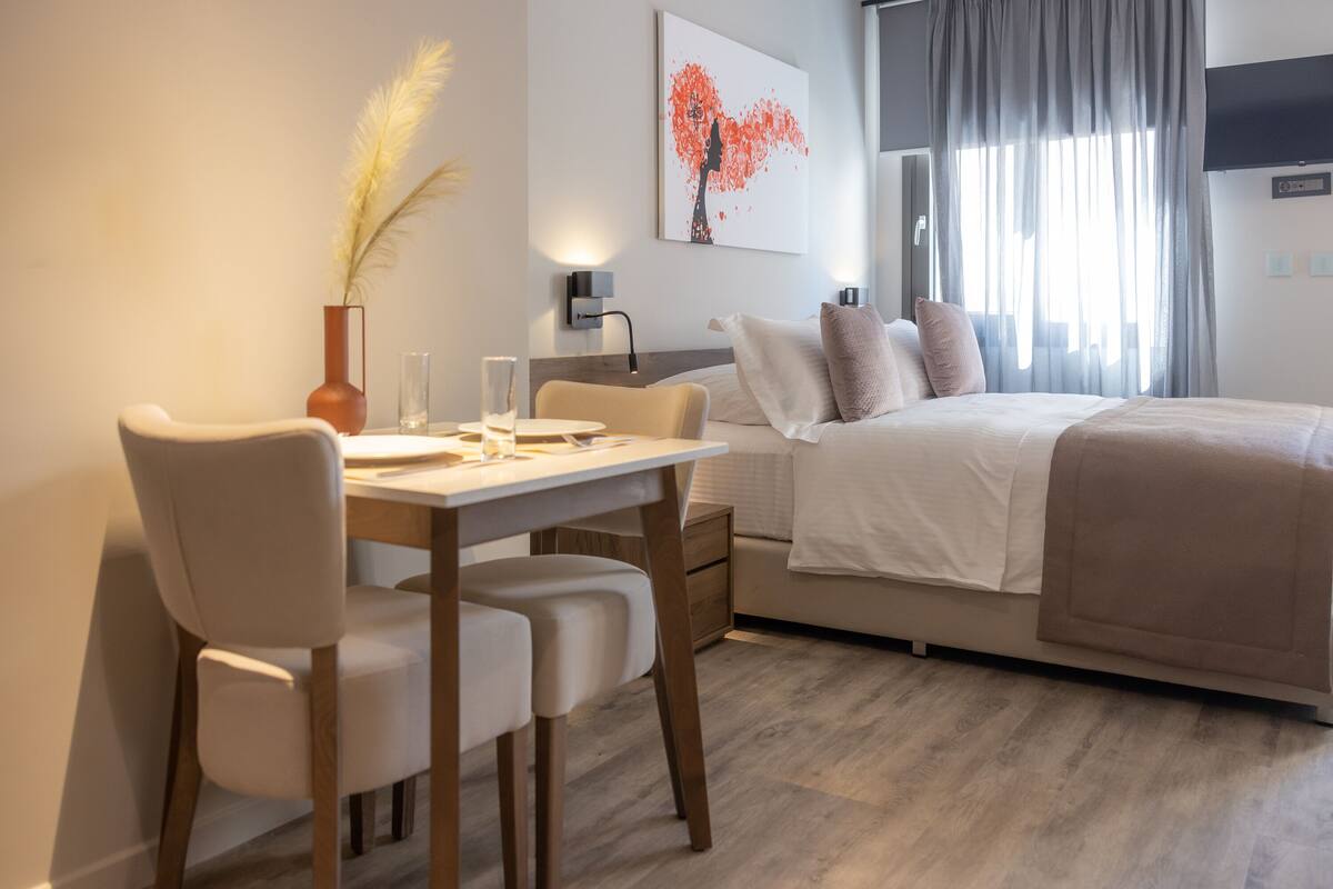 Une chambre moderne avec un lit, une table de chevet et un bureau avec des chaises.
