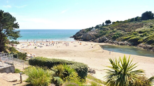 A beach with people, a clear sky, and a rocky hillside. - -HORTENSE- MAISON SABLES BLANCS Á 300M DES PLAGES (Concarneau)