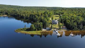 A lakeside property with a house, dock, and surrounding forest.