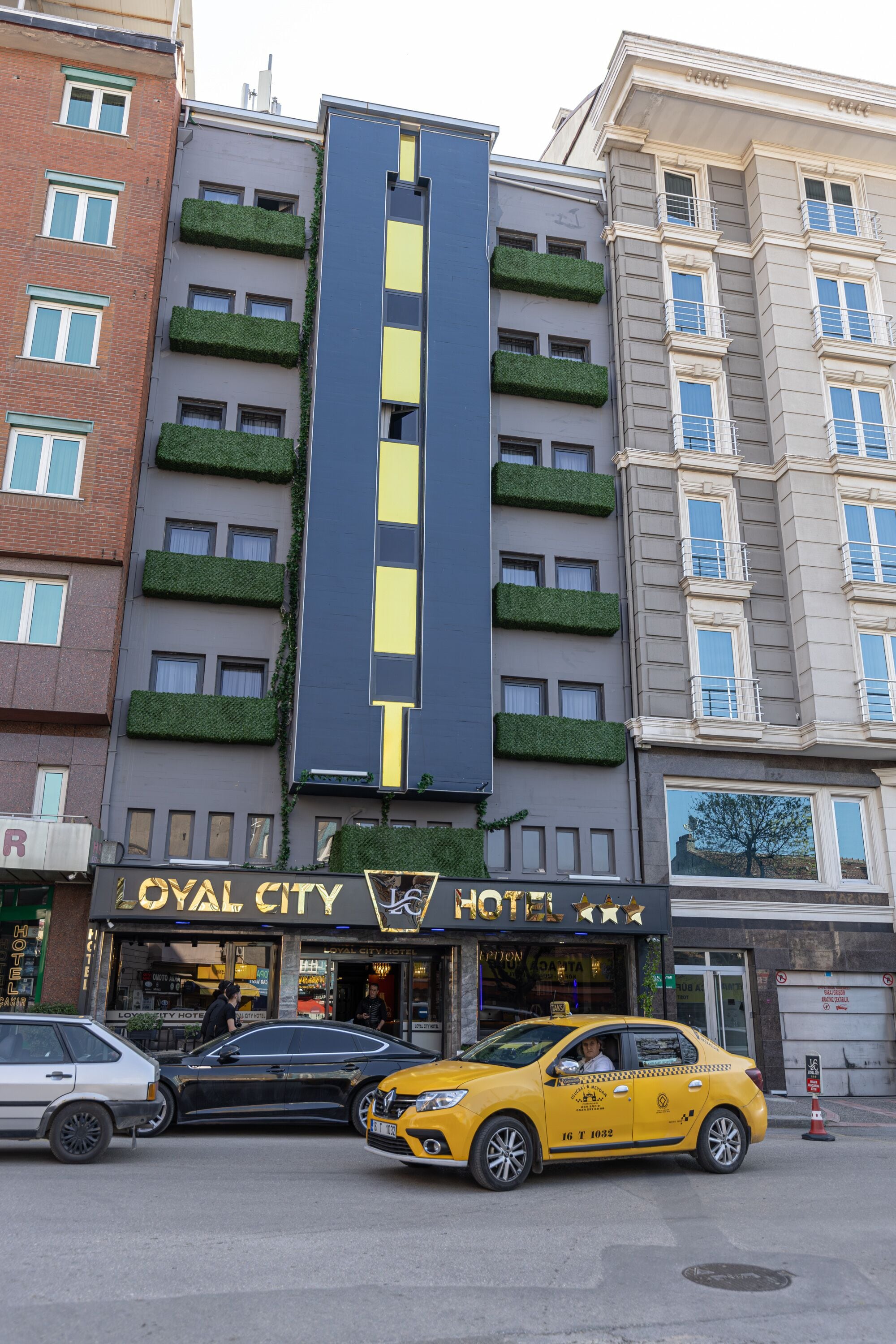 Un hotel con diseño vertical, que cuenta con balcones con vegetación.