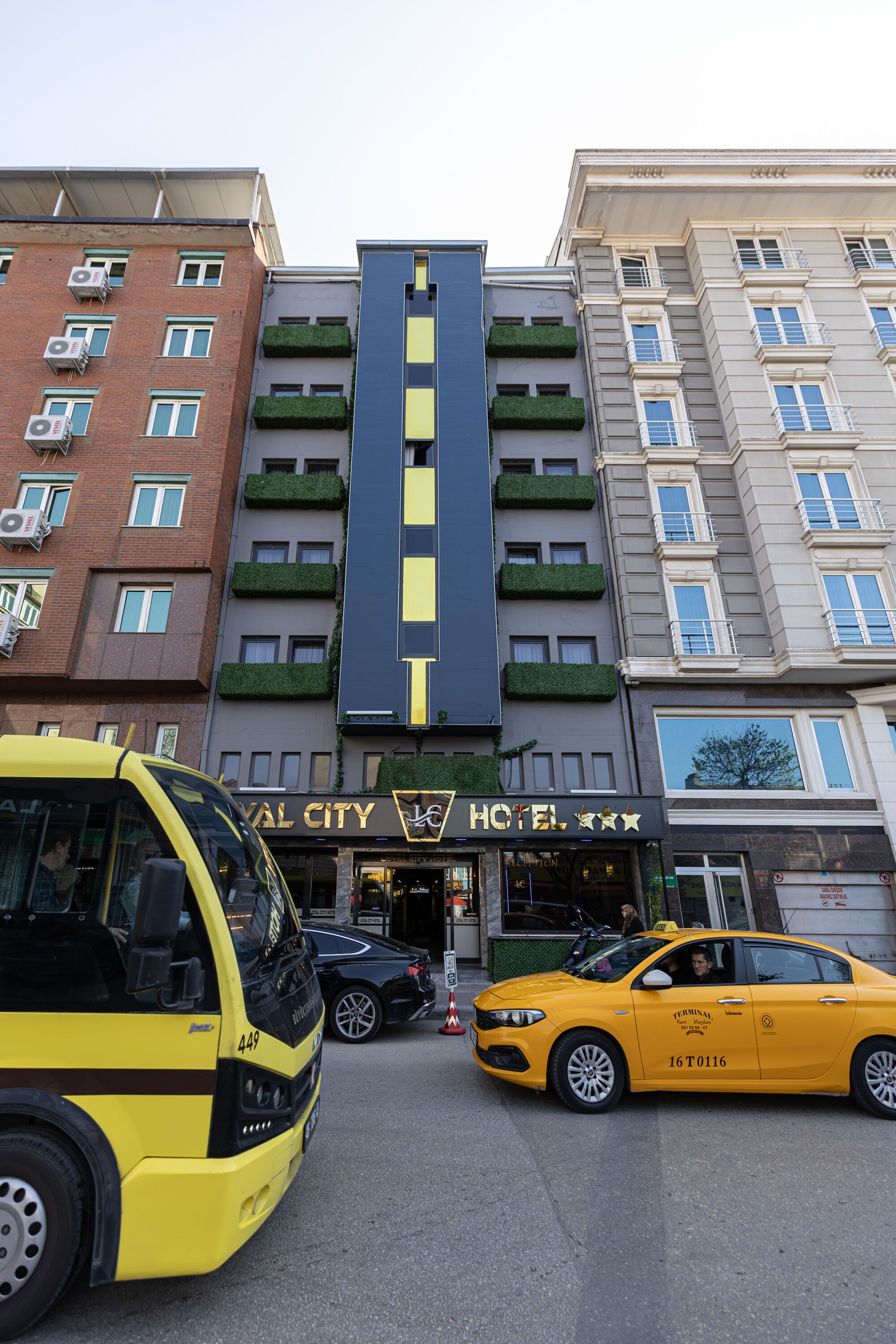 A hotel with a central entrance, multiple floors, and a modern design.