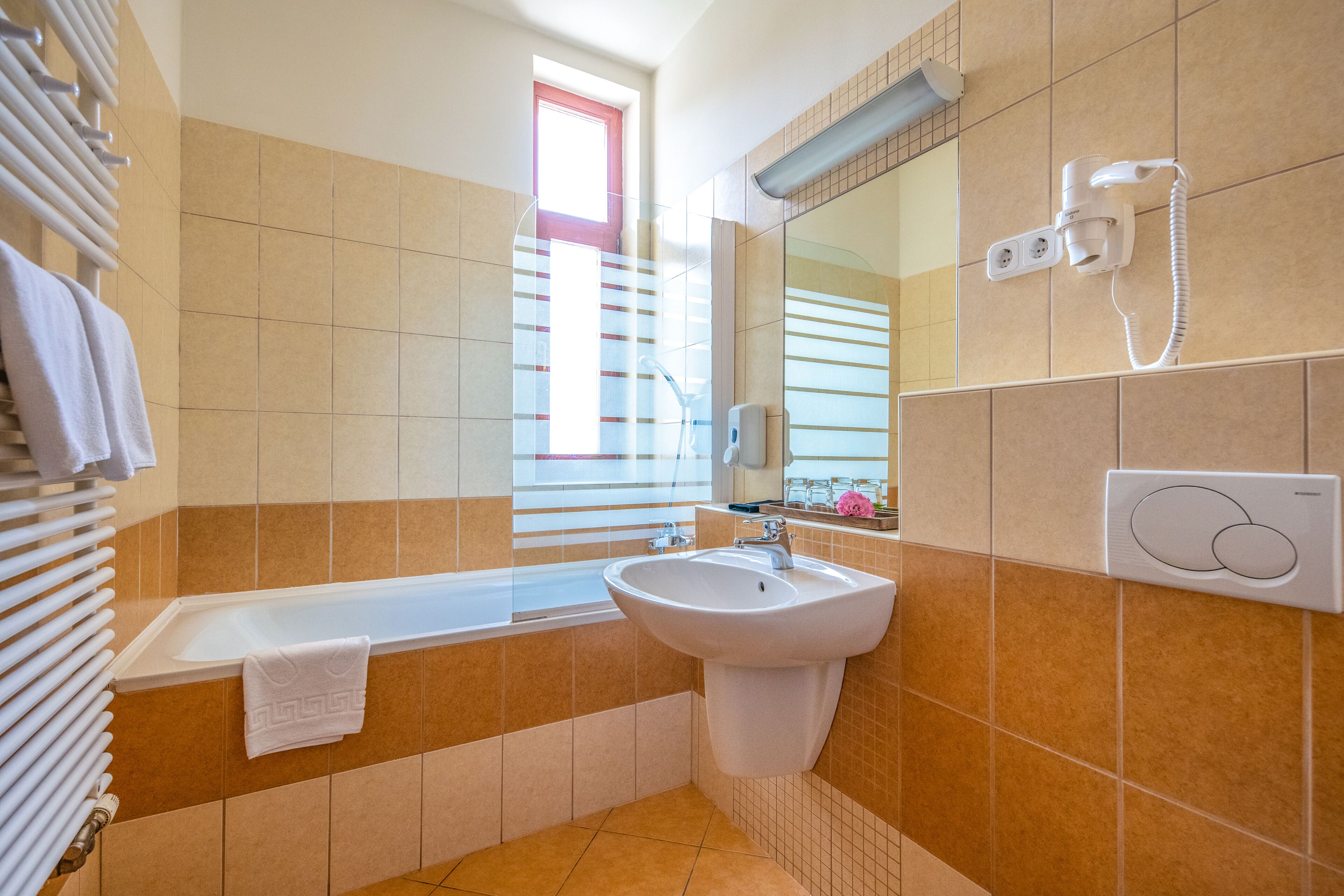 Een badkamer met een badkuip, wastafel en een spiegel.
