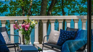 A balcony with a table, chairs, and a vase of flowers. - Hotel Anna Villa (Balatonfoldvar)