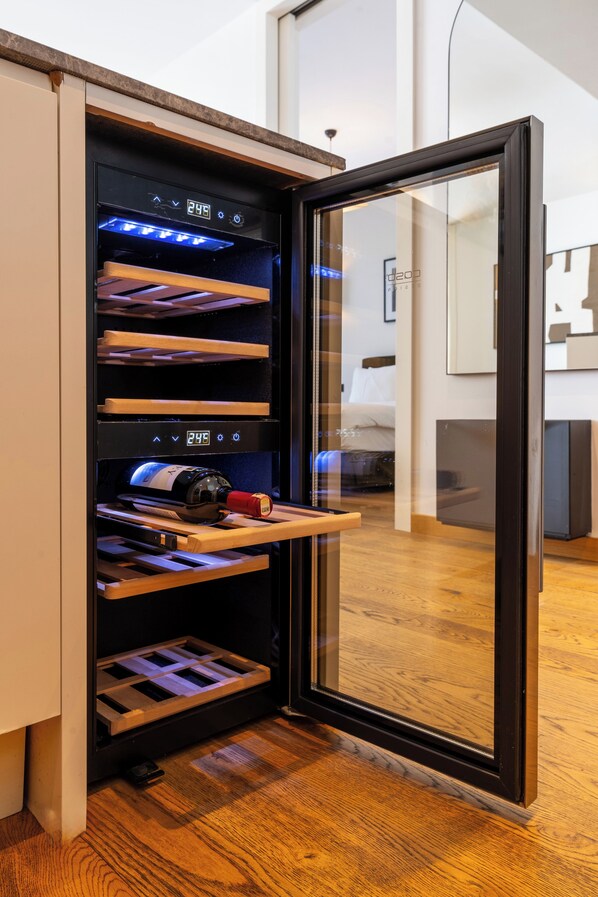 A wine refrigerator with multiple shelves, a digital display, and a wine bottle on the bottom shelf.