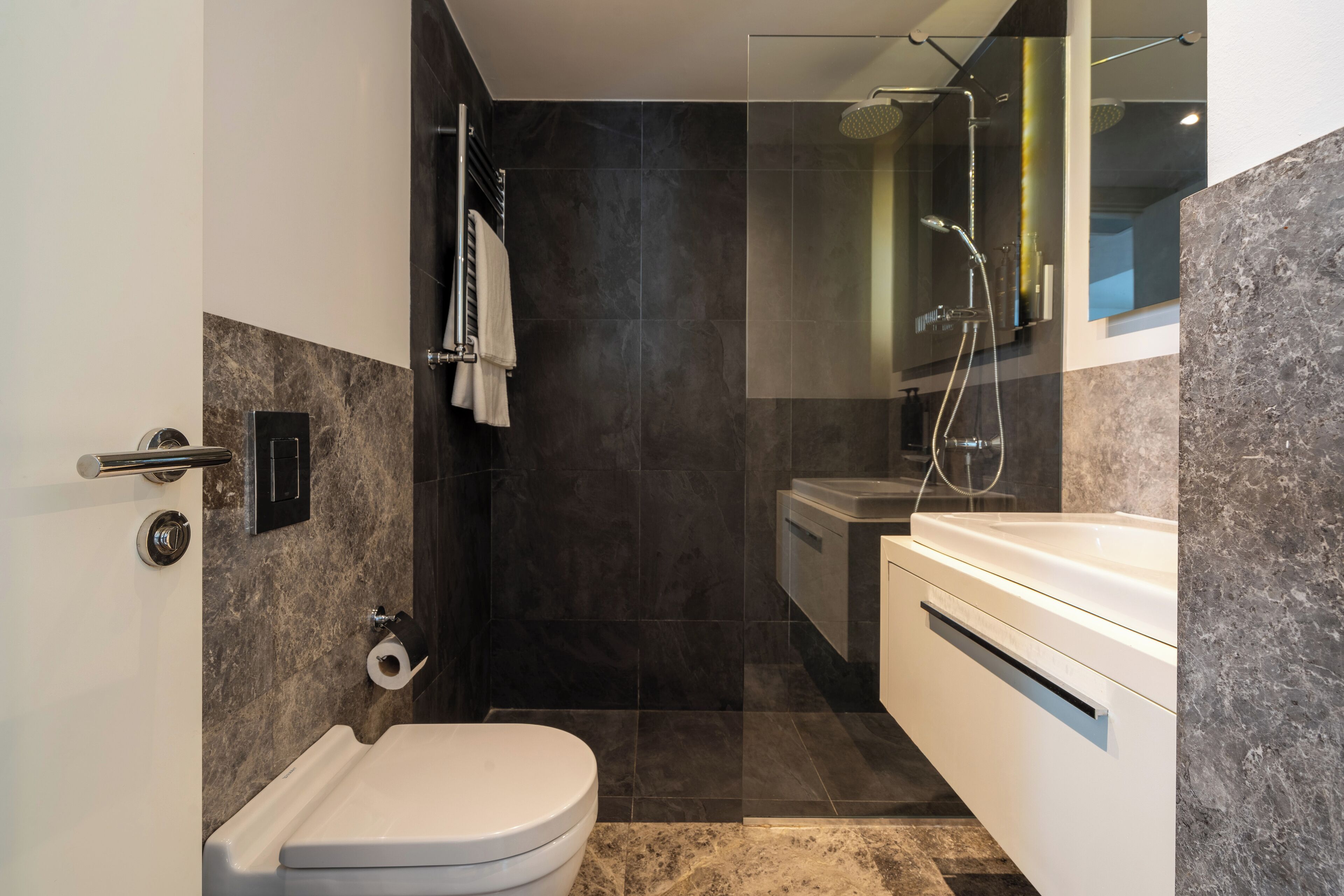 Un baño moderno con inodoro, ducha y lavamanos.