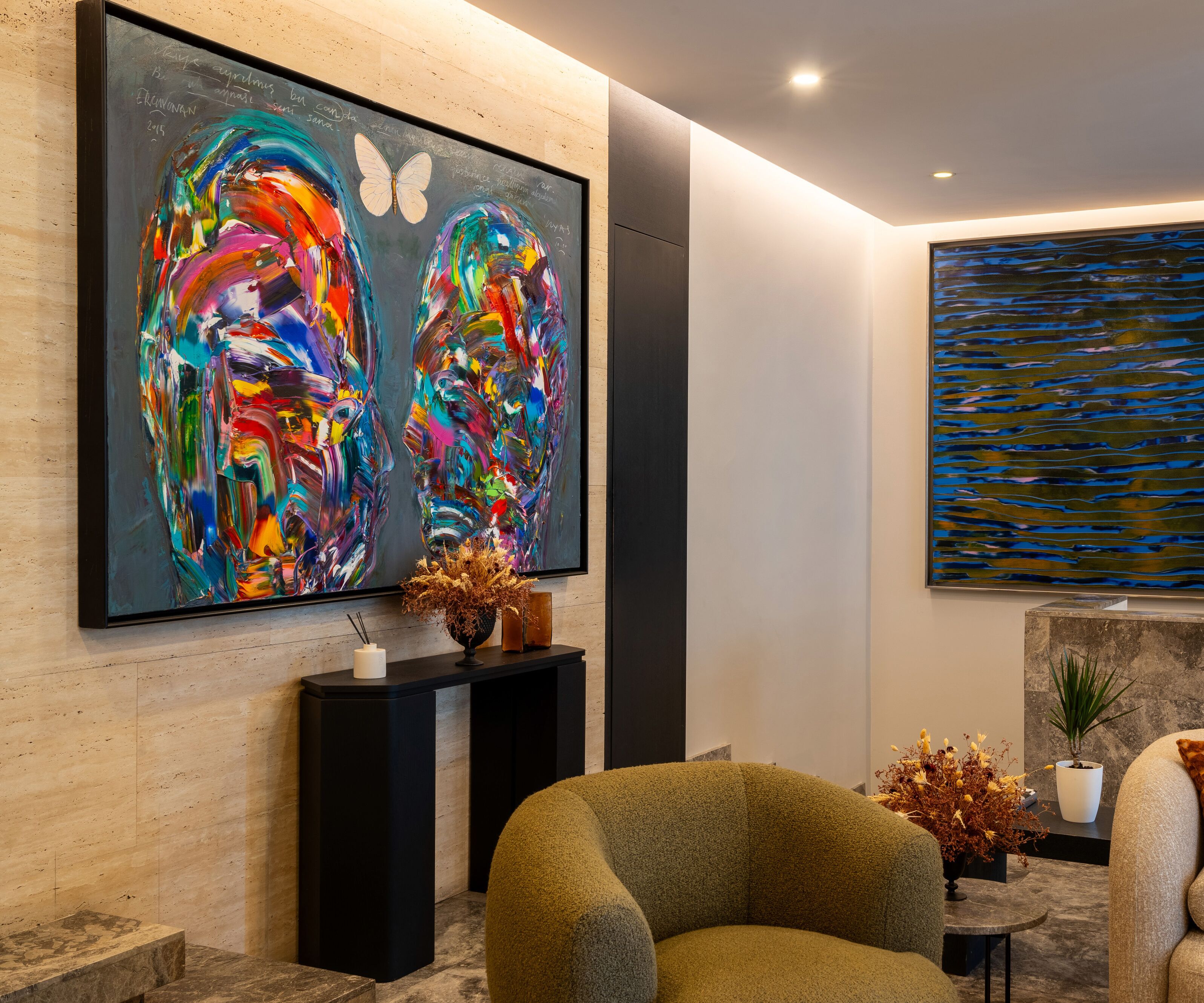 Een moderne lobby met abstracte kunst, een receptiebalie en comfortabele zitplaatsen.
