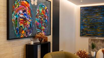 Een moderne lobby met abstracte kunst, een receptiebalie en comfortabele zitplaatsen.