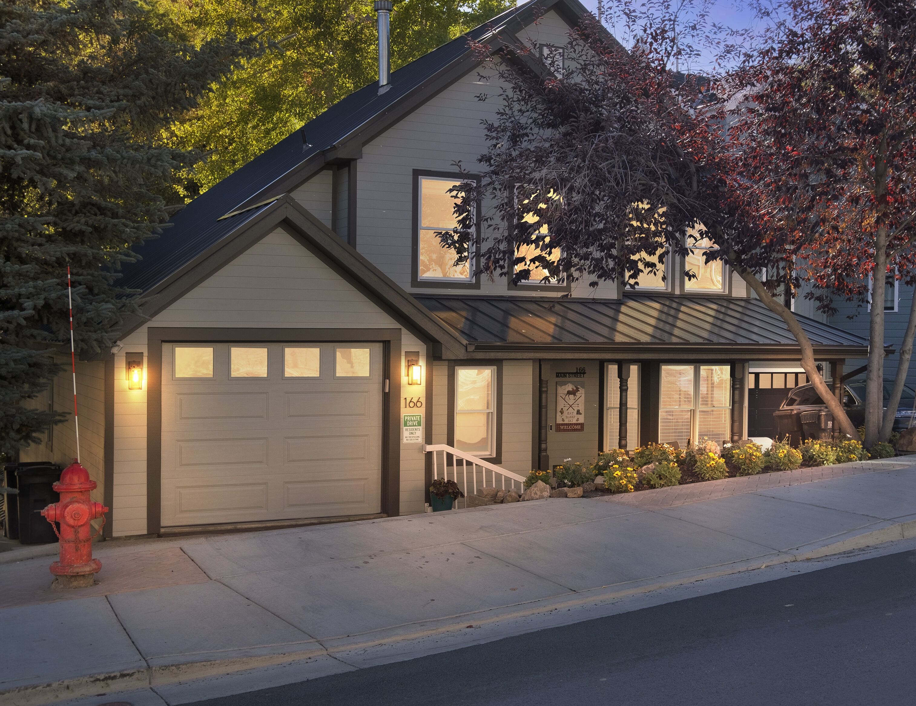 A two-story house with a garage, a front porch, and a driveway.