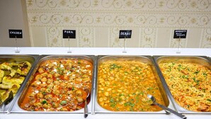 A buffet with labeled sections for chicken, pork, beans, and spaghetti with shrimp. - Parthenon Art Executive Wing (Katerini)