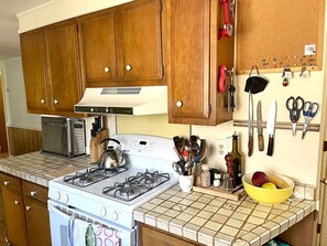 Enjoy cooking in this well-equipped kitchen with a gas stove, kitchen utensils, and appliances.