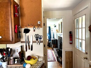 Kitchen with a corkboard, fire extinguisher, and window.