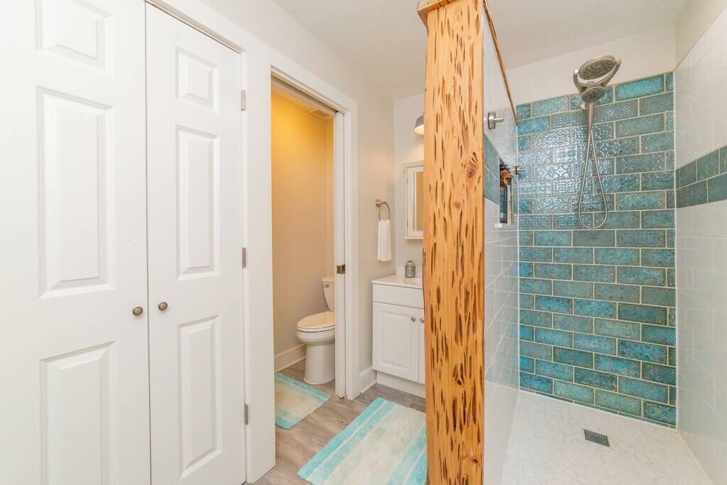 Een badkamer met een douche, toilet en wastafel.