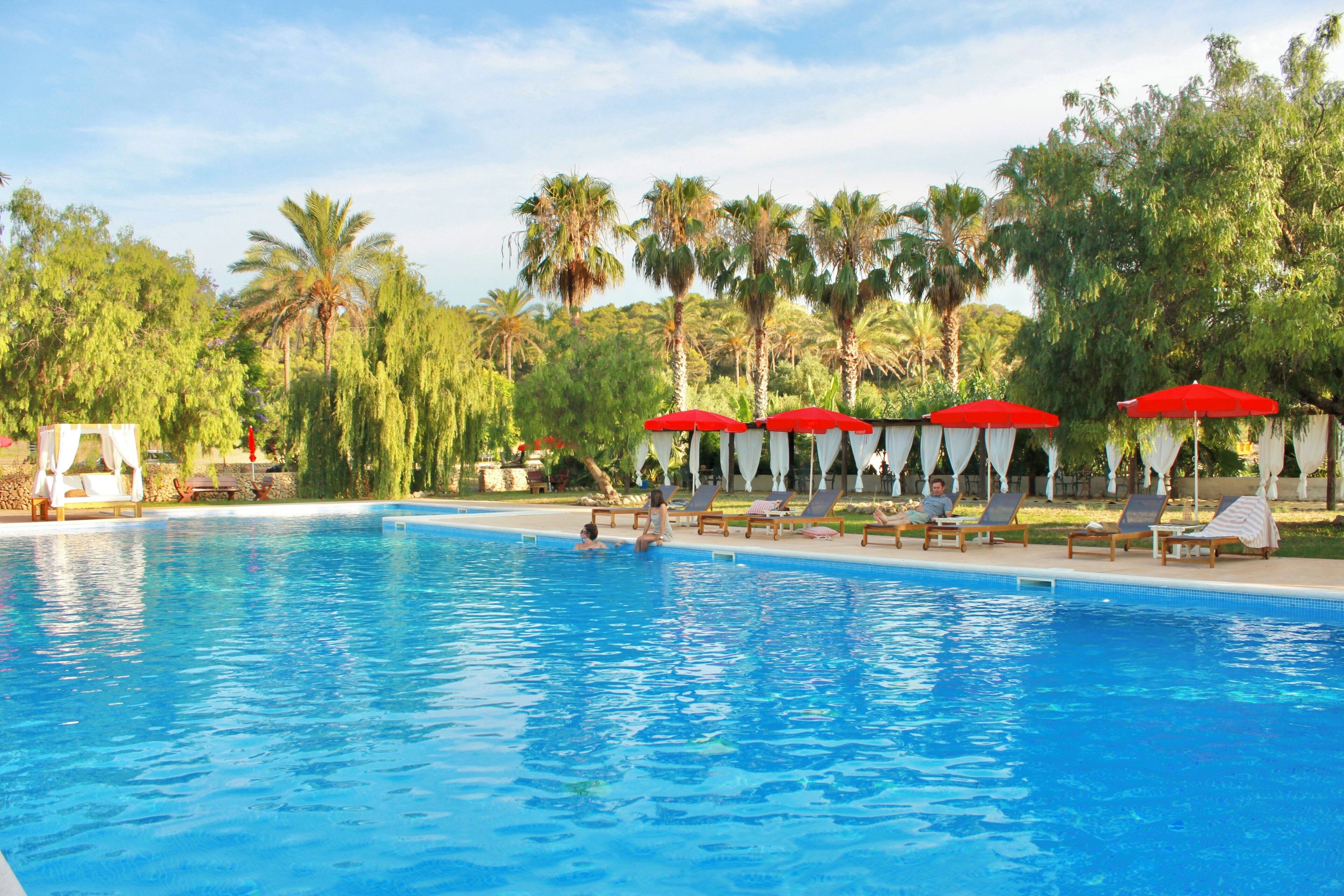 Una piscina al aire libre, sillones reclinables de piscina
