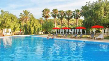 Alberca al aire libre y camastros