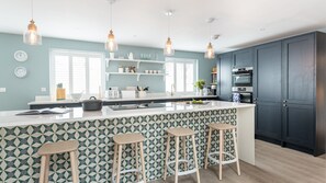 Prepare meals and socialize around the large island with bar stools in this well-equipped kitchen featuring an oven and microwave.