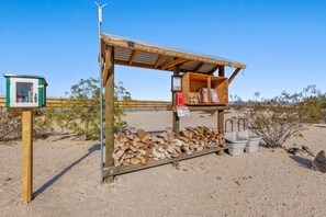 Eine Holzhütte mit Metall-Dach, einem Schild und einem Holzstapel.