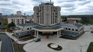 Un hotel moderno con una torre central, varias alas y un amplio patio.