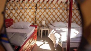 Vista circular de una habitación con dos camas, una mesita y una lámpara.