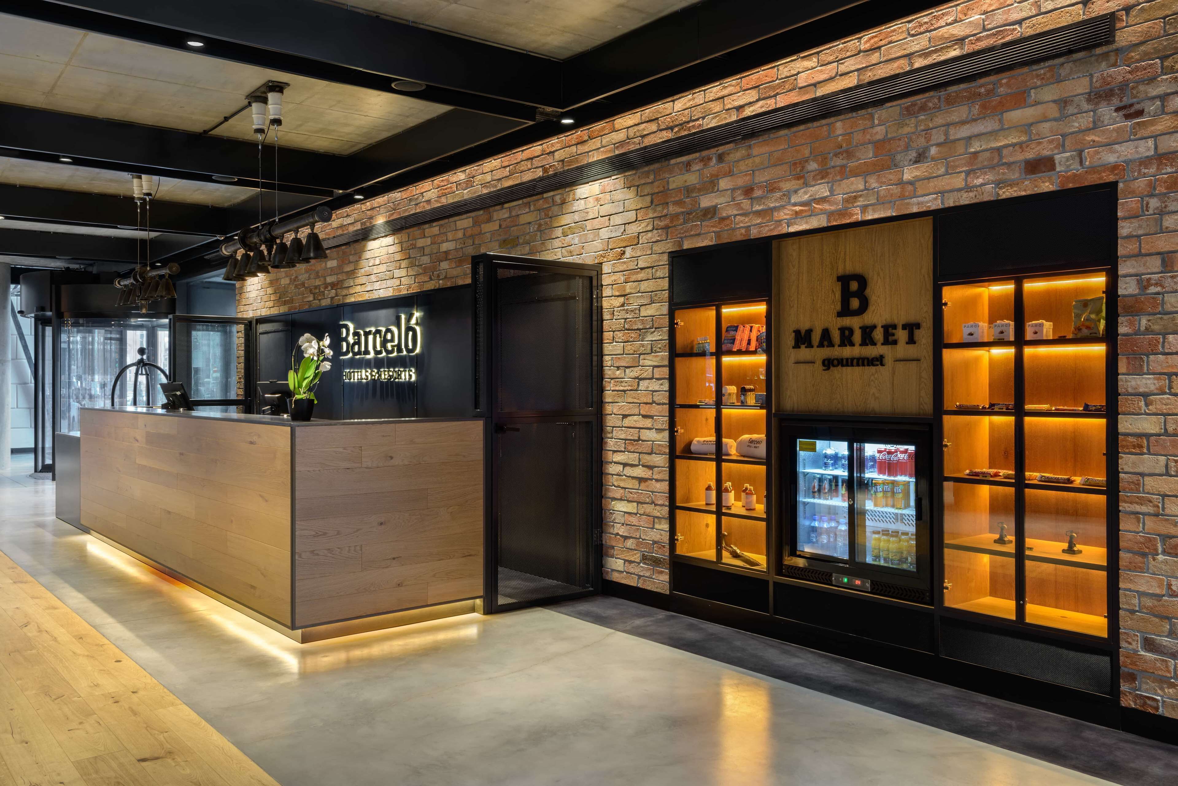 A modern bar with a wooden counter and a brick wall backdrop.