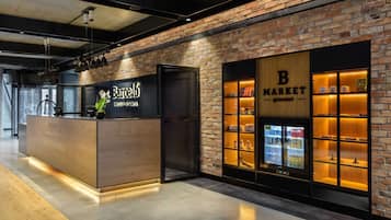 Un bar moderne avec un comptoir en bois et un mur en briques en arrière-plan.