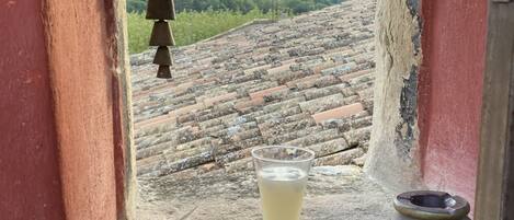 A small stone window with a glass of water, a book, and a small bowl on a stone ledge.