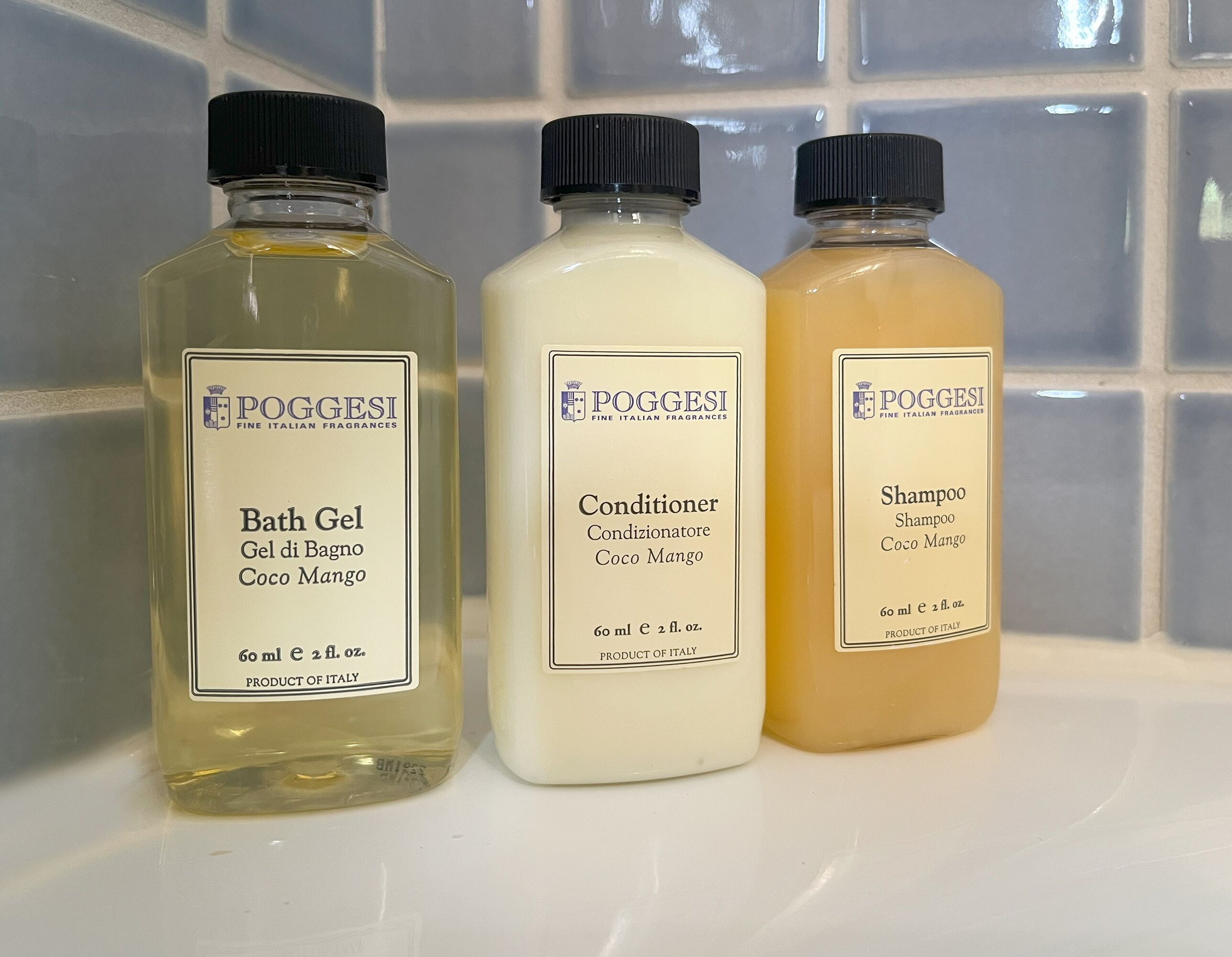 Three bottles of POGGESI Fine Italian Fragrances on a tiled surface.